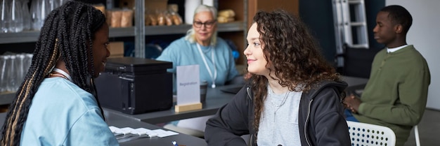 A close-up shot of a government official explaining the Cadastro Único registration process to a citizen at a local community center. The scene should convey trust and helpfulness.
