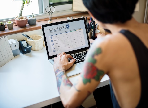 A person using a laptop with the Desenrola Brasil website displayed on the screen showing available debt renegotiation options.