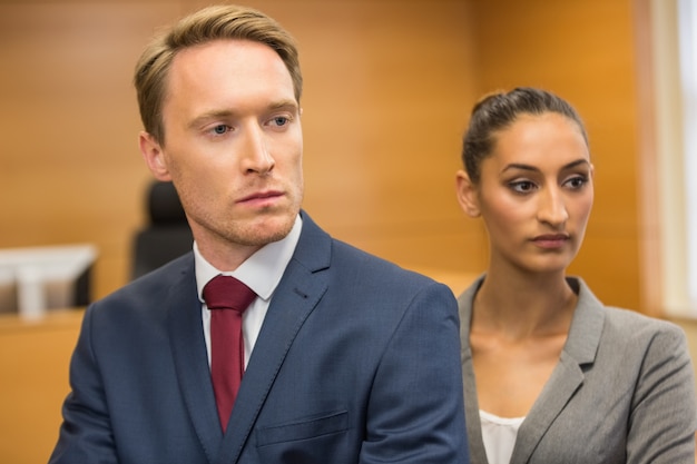 A close-up of two individuals in a professional setting, possibly a lawyer and a client, reviewing legal documents. The lighting is focused, emphasizing the intensity and importance of the review process.