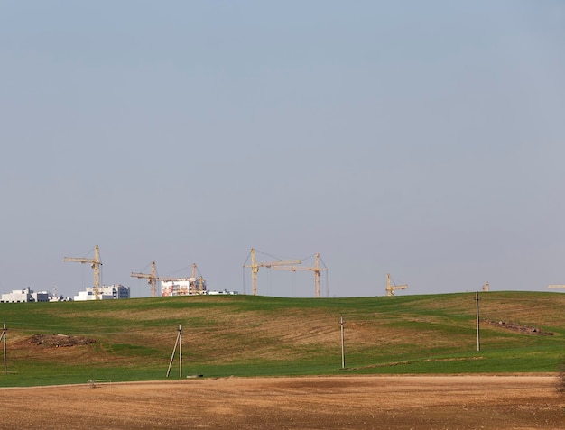 A vast solar panel field in a rural area, with wind turbines spinning in the background.