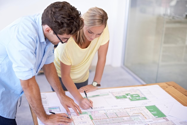 Architects and urban planners discussing blueprints for a new housing development under the Minha Casa, Minha Vida program, emphasizing sustainable and modern designs.