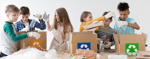 A group of children participating in a recycling workshop, learning about waste sorting and environmental conservation, with a focus on hands-on activities and educational materials.