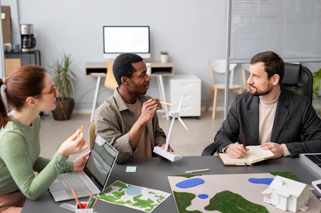 A diverse group of environmental experts reviewing documents and discussing strategic improvements in a modern office setting.