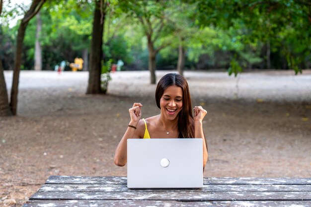 A Brazilian student happily receiving an acceptance letter to university while sitting at a computer, with the national flag subtly displayed in the background.