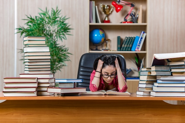 A stressed-looking Brazilian teacher sitting at their desk, surrounded by piles of papers and student assignments. The image should emphasize the mental and emotional toll that teaching can take.