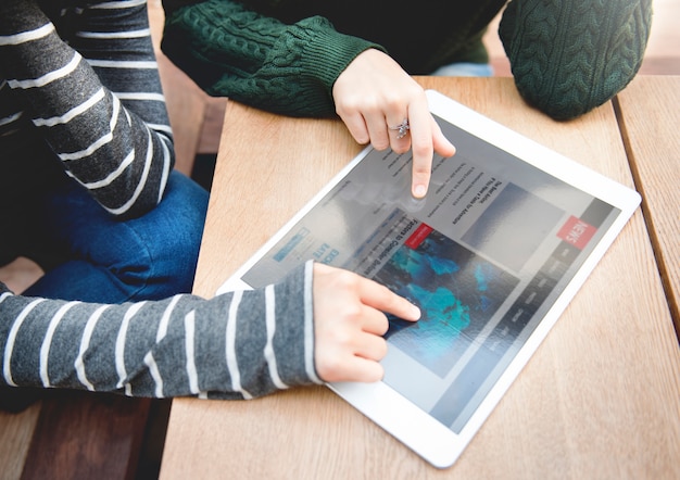 Close-up of a student's hands selecting an option on a digital tablet showing different career paths and academic disciplines, with icons representing each choice.