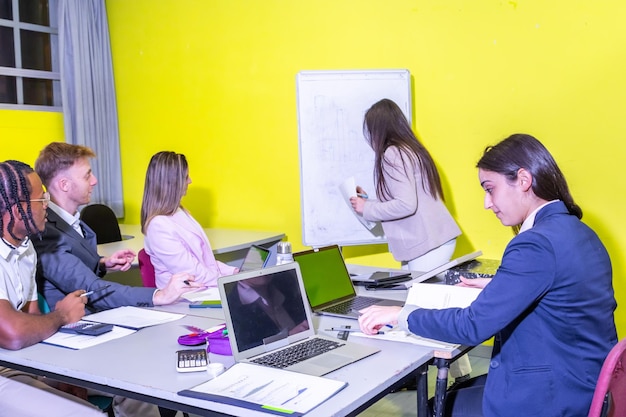 Teachers participating in a workshop-style activity with laptops and interactive displays in a room setup for collaboration.