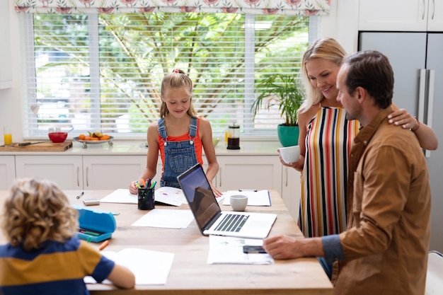 A family sitting together at a table, reviewing their household budget and discussing financial goals with their children.