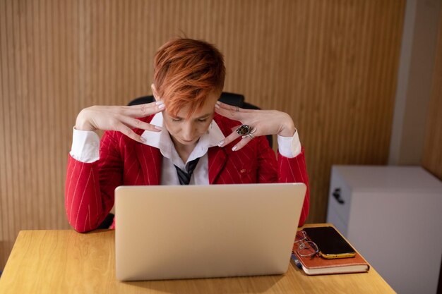 A close-up shot of a frustrated student in front of their computer screen, with a slow internet loading icon visible. The student is struggling with technical issues, highlighting the challenges of accessing online education.