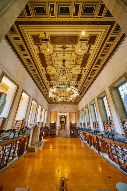An interior view of the Pinacoteca do Estado de São Paulo, featuring a vast hall filled with artworks from the 19th and 20th centuries. Natural light streams in through the large windows, illuminating the paintings and sculptures on display, creating a serene and inviting atmosphere for visitors.