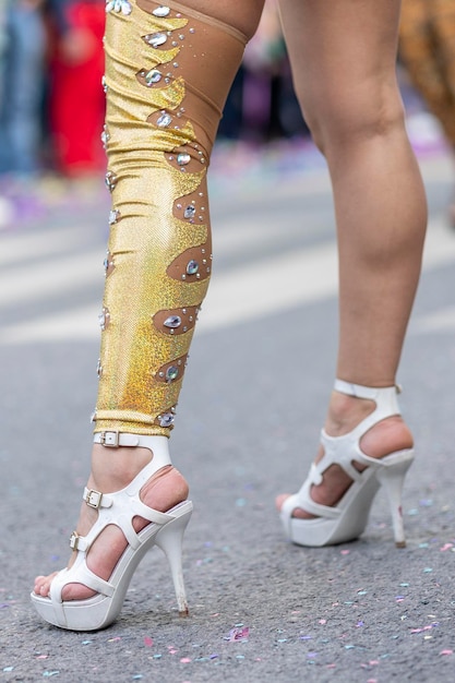 A close-up of a Frevo dancer's feet performing intricate steps on a cobblestone street during a carnival parade. The image focuses on the movement and energy of the dance.