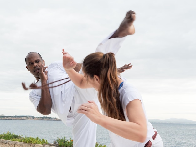 A group of diverse people of all ages engaged in a capoeira class, showcasing the inclusivity and community aspect of the practice.