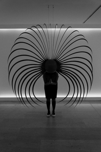 A black and white photograph of an art installation in a gallery. The installation features recycled materials arranged in a thought-provoking way, symbolizing environmental conservation and sustainability.