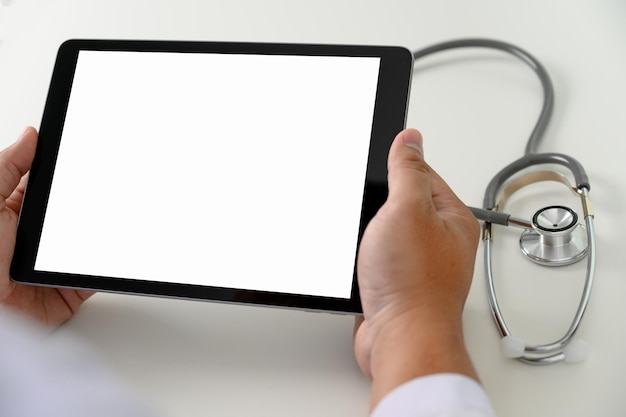 A close-up of a doctor's hands holding a tablet showing a patient's health record. The background shows a blurred hospital environment. The image emphasizes technology in healthcare and improved patient care.