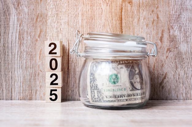 A hand placing coins into a piggy bank labeled 